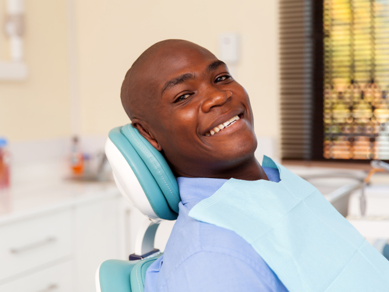 smiling man sitting in a dentist chair