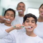 family brushing their teeth together for good oral health habits