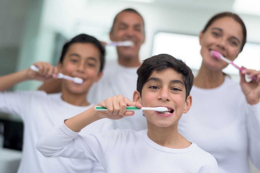 family brushing their teeth together for good oral health habits